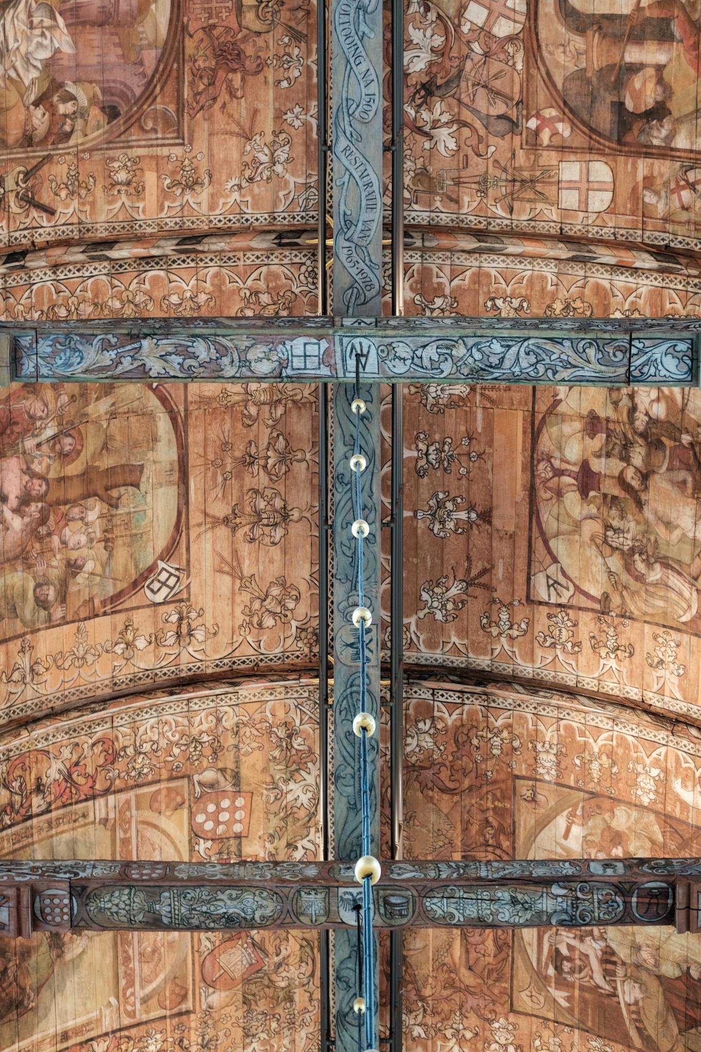 Detailed fresco and carvings on the church's gothic vaulted ceiling in Naarden, Netherlands.